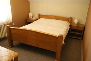 une chambre avec un lit en bois et deux tables de nuit dans l'établissement B&B Vila Bela Ruza, à Sremska Mitrovica