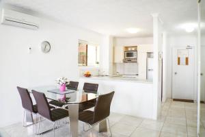 cocina y comedor con mesa y sillas en Surfers Riverside, en Gold Coast