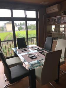 a dining room table with chairs and a large window at Kizuna no Ie in Uozu