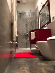 a bathroom with a shower and a red rug at Nonna Anna in Siena +12 photos