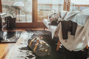 a living room with a couch and a bag on the floor at Kangaroo Ridge Retreat in Healesville