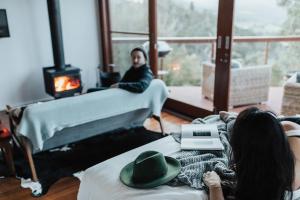 Dos mujeres acostadas en una cama con un hombre al fondo en Kangaroo Ridge Retreat, en Healesville