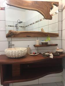 a bathroom with a counter with a sink and a mirror at Ô Fil de l'Eau in Pointe-Noire