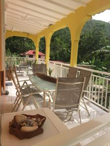 un patio con mesa y sillas en una terraza en Ô Fil de l'Eau, en Pointe-Noire