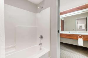 a bathroom with a tub and a sink and a mirror at Days Inn by Wyndham Norton in Norton +30 photos