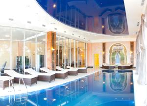 una hall con piscina e sedie di Kainar Hotel a Shymkent