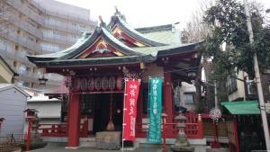 a small shrine in a city with a building at Hotel Neo Rouge in Tokyo