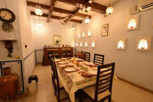 a dining room with a table with chairs and a clock at Jaswant Niwas in Jodhpur +77 photos