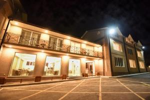 een gebouw met een balkon en een parkeerplaats 's nachts bij Laguna Hotel in Vanadzor