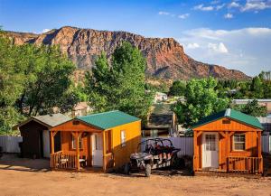 two tiny houses in front of a mountain at Zion’s Cozy Cabin's in Hildale