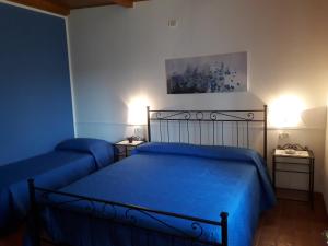 a bedroom with two beds with blue sheets at Poderone Vecchio in Sorano