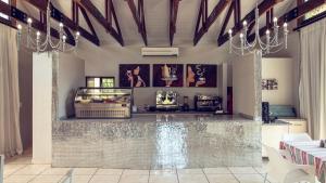 a restaurant with a bar with a counter in a room at Machauka Lodge in Lephalale
