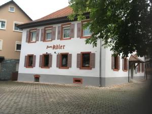 a white building with brown windows on a street at Gasthaus zum Adler in Baden-Baden