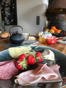 un piatto di alimenti con fragole e carne su un tavolo di Maison Galerie Art n Pepper a Solwaster