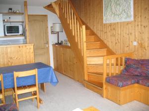 a dining room with a table and a staircase at La Tania Kalinka Duplex in La Tania