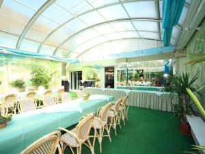 een groep tafels en stoelen in een kamer bij Hotel Maromme in Norderstedt