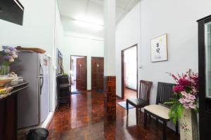 a living room with a refrigerator and wooden floors at Hin Loi Guesthouse in Kota Kinabalu