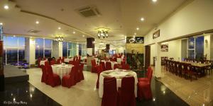 a restaurant with red chairs and tables and tablesearcher at Sai Gon Ban Me Hotel in Buon Ma Thuot