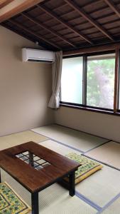 a room with a wooden table in front of a window at Minshuku Ginmatsu in Kanazawa