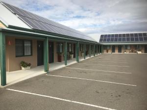 a parking lot with solar panels on the side of a building at The Bakehouse Motel in Goulburn