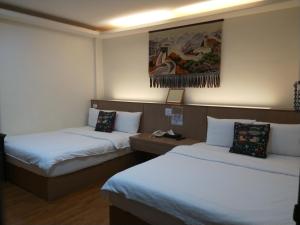 a room with two beds and a painting on the wall at Oriental Hotel in Taimali