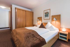 Postel nebo postele na pokoji v ubytování Hotel Vier Jahreszeiten