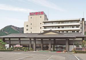 un edificio con un parcheggio di fronte di Itoen Hotel New Sakura a Nikko