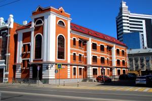 un bâtiment orange et blanc sur le côté d'une rue dans l'établissement Hotel 55, à Kazan
