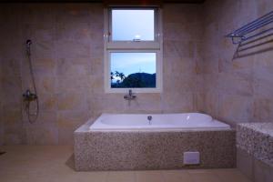 a large bath tub in a bathroom with a window at DooDoo B&B in Jiji +39 photos