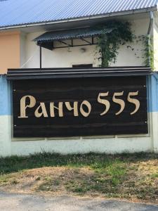 una señal negra en el costado de un edificio en Rancho 555 en Úzhgorod