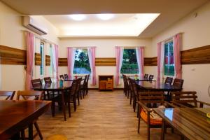 a dining room with tables and chairs and windows at DooDoo B&B in Jiji