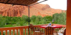 a table and chairs on a balcony with a view of a mountain at kasbah Ait arbi in Aït Ougliff