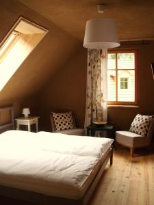 a bedroom with a bed and two chairs and a window at Ferienhof Idyll am kleinen Fließ in Burg