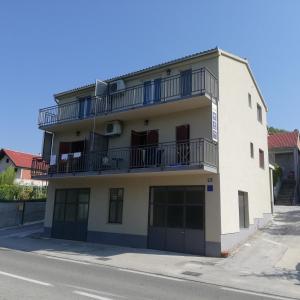 an apartment building with a balcony on the side of the street at Apartments Sadina in Skradin