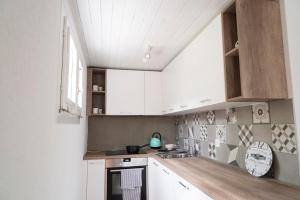 een keuken met witte kasten en een wastafel bij Modern charme studio in Chalet in Ponto Valentino