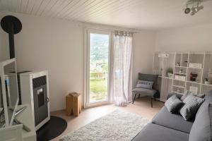 uma sala de estar com um sofá e uma janela em Modern charme studio in Chalet em Ponto Valentino