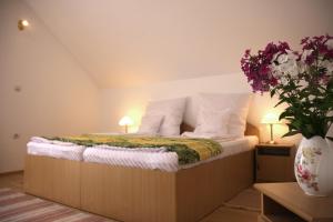 1 dormitorio con 1 cama con 2 lámparas y flores en Pensiunea Sighisoara, en Sighişoara