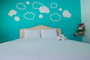1 dormitorio con 1 cama con nubes en la pared en A Nice Resort, en Buriram