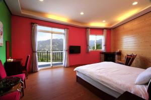 una camera da letto con un letto grande e una grande finestra di Yun Meng Xianjing Homestay a Ren'ai