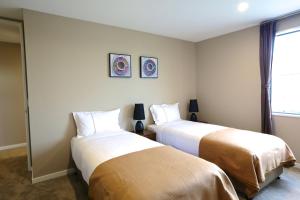 a bedroom with two beds and a window at Golden Sun Apartment -Two bedrooms, Three bedrooms in Christchurch