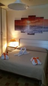 1 dormitorio con 1 cama con 2 toallas en Arcobaleno, en Campagna