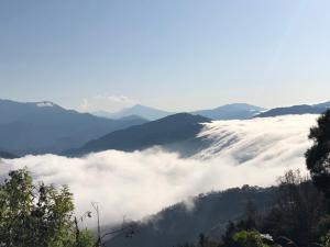una vista di una valle di nuvole tra le montagne di Yun Meng Xianjing Homestay a Ren'ai