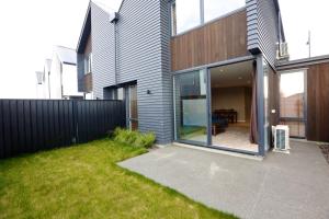 a house with a sliding glass door in a yard at Golden Sun Apartment -Two bedrooms, Three bedrooms in Christchurch