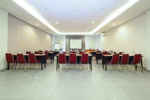a conference room with tables and chairs and a screen at Amaris Hotel Sriwedari Solo in Solo