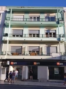 a tall building with people walking in front of it at Casa Maria in Nazaré +25 photos