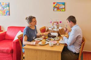 Een man en een vrouw die aan een tafel eten. bij Penzion & Vinný bar Régio in Kyjov