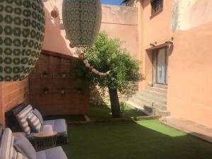 une terrasse avec une cour verdoyante dotée de chaises et d'un arbre. dans l'établissement Colores de Buendía, à Buendía