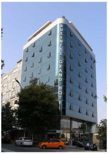 a large building with cars parked in front of it at Business Grand Hotel in Ankara