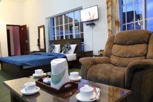 a living room with a couch and a bed at Dewdrops at Lake Gregory in Nuwara Eliya