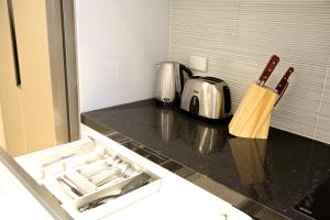 a kitchen with a counter with a sink and a stove at Golden Sun Apartment -Two bedrooms, Three bedrooms in Christchurch